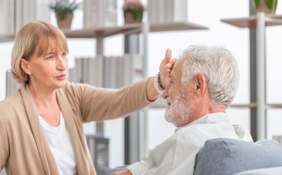 Woman checking fever on forehead by hand, Elderly woman touches the forehead of old husband, Senior couple and happy family concepts photo