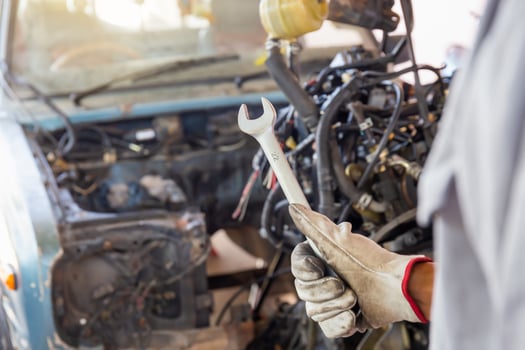 Hand of car mechanic holding wrench, Automotive repair service in the workshop photo