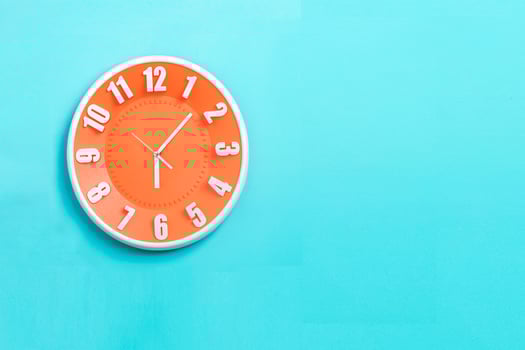 beautiful Orange wall clock on blue background ,concept of Start the morning to work. photo