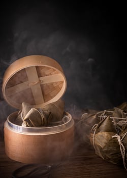 Zongzi, steamed rice dumplings in steamer on wooden table, famous tasty food in dragon boat festival duanwu design concept, close up, copy space. photo