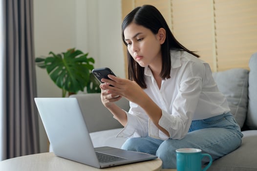 Young happy woman relaxing and using smart phone at home, social media and technology concept. photo