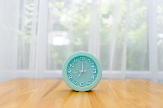 Light green alarm clock Placed on the table in the bedroom photo