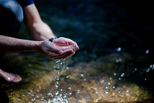Hands and water flowing from natural waterfalls Water concept from natural waterfall photo