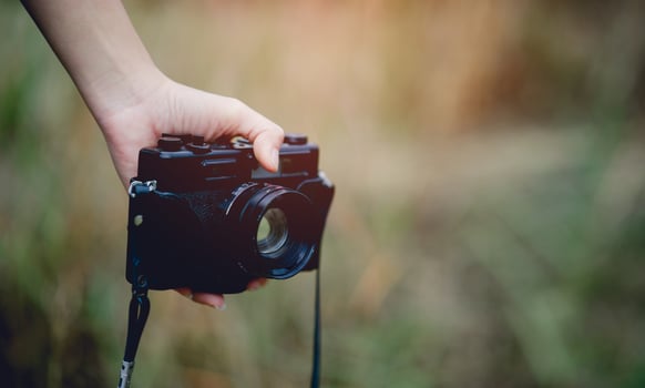 Hand and camera of the photographer Holding and carrying the camera to take pictures photo