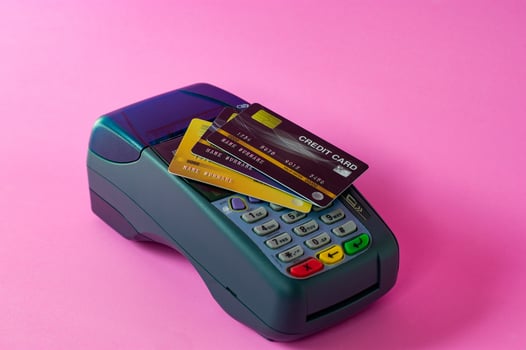 Credit card and credit card scanner on a pink background photo