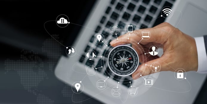 Businessman with a compass holding in hand on laptop and icon customer network connection on screen, m-banking and omni channel photo