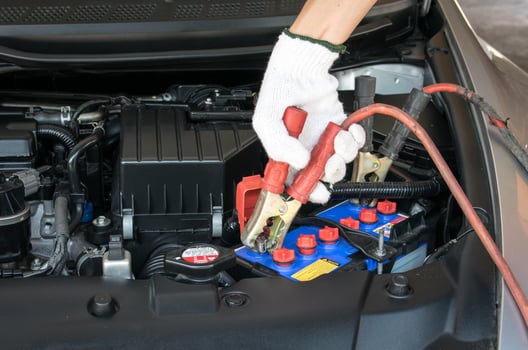 automotive technician charging vehicle battery photo