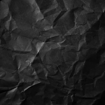 Textured crumpled black paper background. photo
