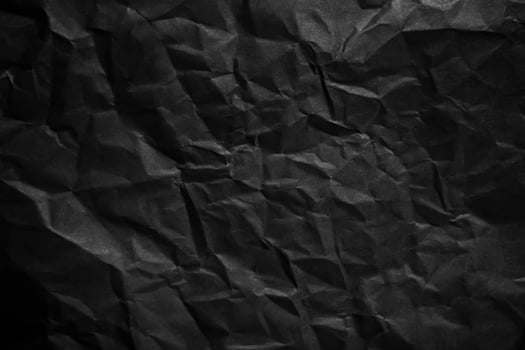 Textured crumpled black paper background. photo