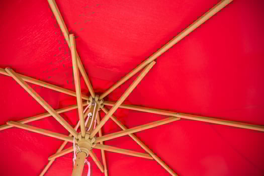Under red summer parasol with vintage style antique wooden frame. photo