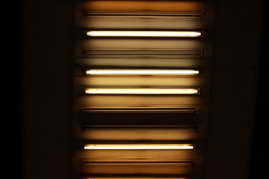 Warm fluorescent light lined up dark background dramatic light photo