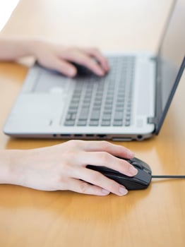Female hand with computer mouse on table, closeup photo