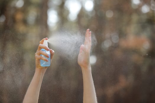 Womans hand pressing Alcohol Spray in the nature for clean her hand. Alcohol Spray is very important in daily life. mosquito repellent or antiseptic photo