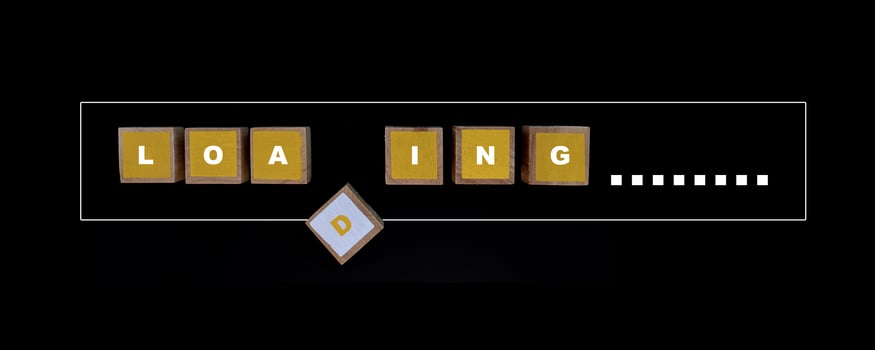 Square wood painted yellow and white color with LOADING letters in progress bar on a black background. photo