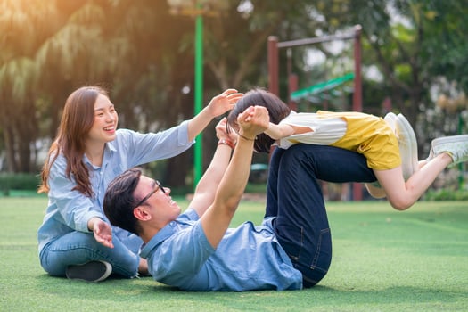 Image of young Asian family playing together at park photo