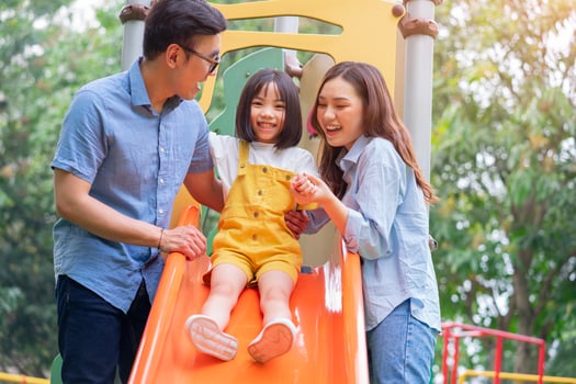 Image of young Asian family playing together at park photo