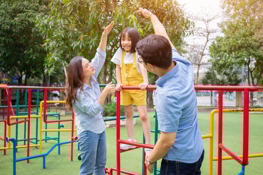 Image of young Asian family playing together at park photo