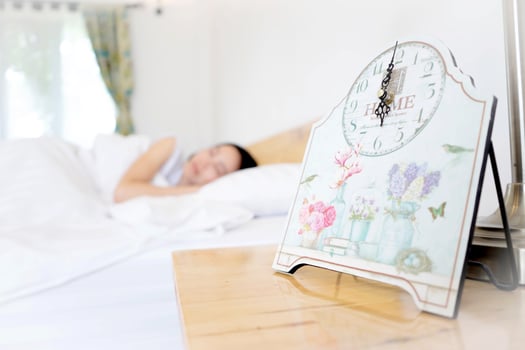 Young woman sleeping in bed with alarm at night photo