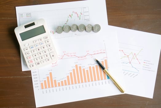Calculator, coins and pen laying on chart. Concept of finance. photo