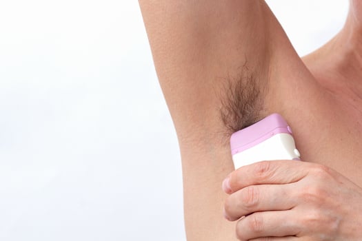 Hand removing hair from armpit by epilator photo