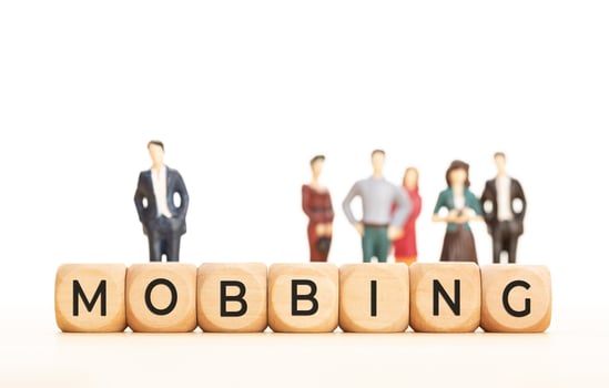 Mobbing concept. Wooden blocks with text and human figurines at background. Copy space photo