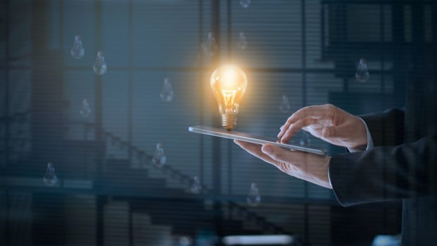 Glowing light bulb over labtop of businessman among the others that not bright, it's symbolic of creative and bright idea or leadership, innovation and creativity concept photo