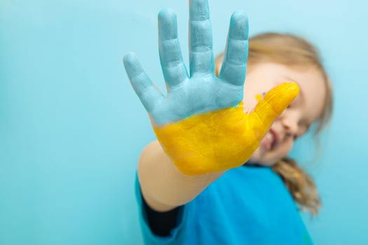 Yellow and blue paint on the hand of a little girl. Ukrainian flag symbols concept photo