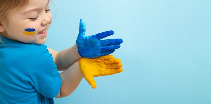 Yellow and blue paint on childrens hands. Ukrainian flag symbols concept. Copy space photo