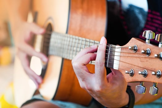 Practicing guitar playing a beautiful Asian man playing guitar photo
