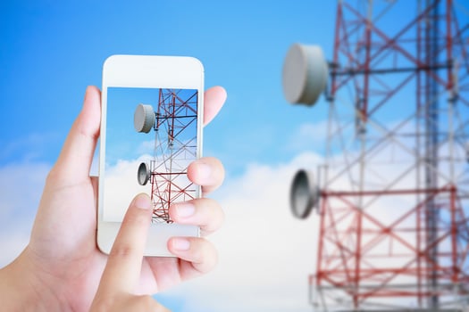 hand hold mobile smartphone with telecommunication tower photo