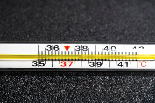 Mercury thermometer  on black background. Close up photo. Thermometer shows a temperature of 38 degrees Celsius photo