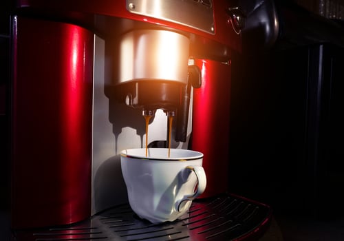 Cup of coffee in the coffee machine close up photo