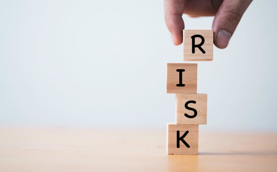 Hand putting and stacking wooden cube block of risk wording for risk management concept. photo