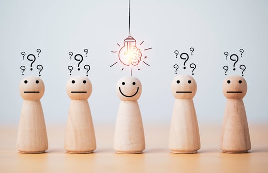 Smiley wooden human with light bulb and others human with question mark for creative thinking and problem solving solution concept. photo