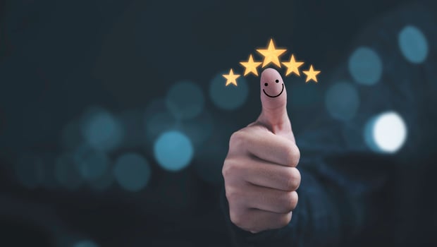 Thumb rise up with yellow five stars and smile face for customer satisfaction and evaluation after use product and service concept. photo