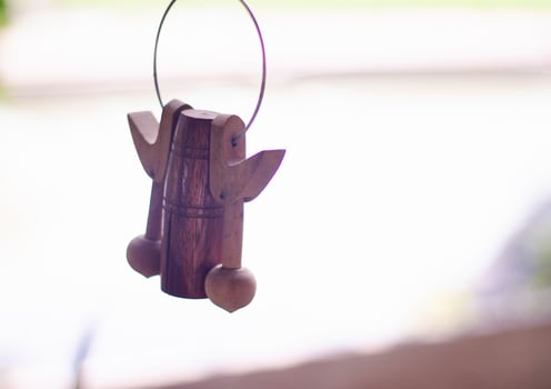 Handmade wooden bell hanging on the house's windows . photo