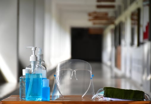 Covid 19 protective equipments on table, facemask, hand sanitizing gel, faceshield, alcohol gel, photo