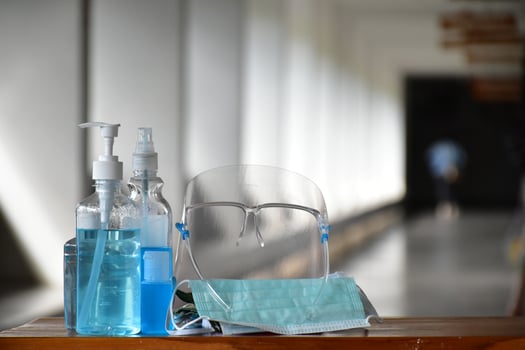 Covid 19 protective equipments on table, facemask, hand sanitizing gel, faceshield, alcohol gel, photo