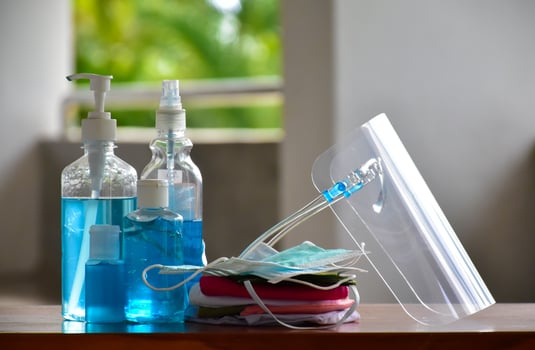 Covid 19 protective equipments on table, facemask, hand sanitizing gel, faceshield, alcohol gel, photo