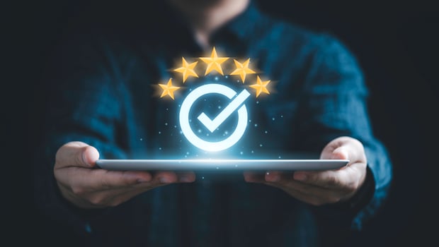 Businessman holding tablet and showing the best quality assurance with golden five stars for guarantee product and ISO service concept. photo