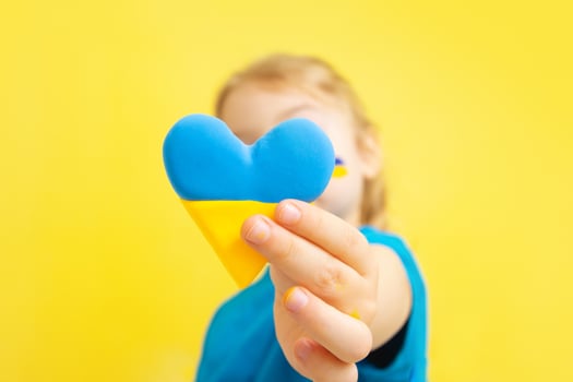 The girl holds a heart of yellow and blue color of the Ukrainian flag. Love to Ukraine concept photo