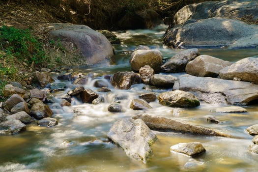 Water flowing along rocks in nature, waterfall photo