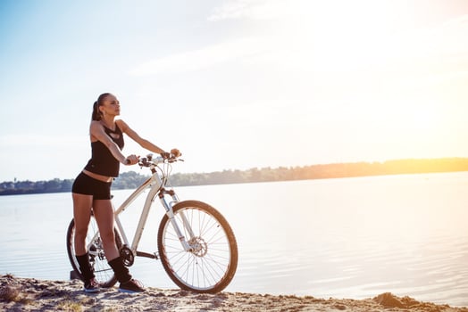 woman on a bicycle near the water photo
