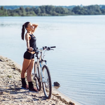 woman on a bicycle near the water photo