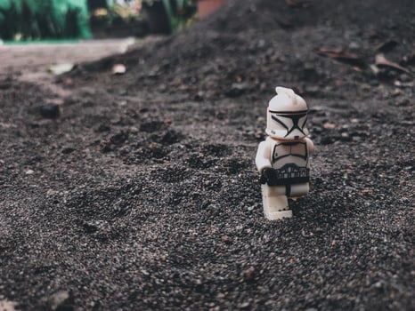 an action figure clone trooper with black sand background photo