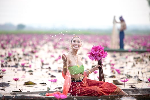 Young Asian women in Traditional dress in the boat and pink lotus flowers in the pond.Beautiful girls in traditional costume.Thai girl in retro Thai dress, Thai girl in traditional dress costume photo