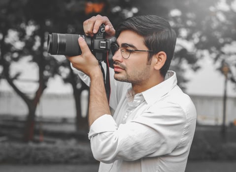 A Young Indian boy capturing the moment in wedding from camera. photo