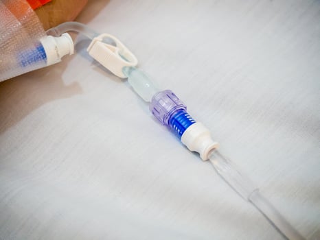 Asian woman patient hand on IV drip with saline solution, fluid replacement therapy photo