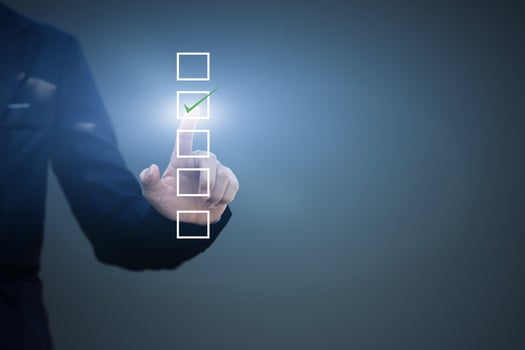 Businessman touch checking mark in a checkbox on blue background. copy space photo