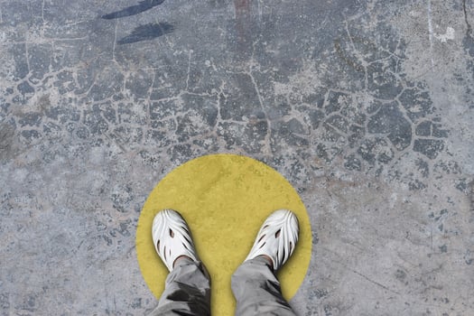 Top down of feet standing in yellow circle on flooring. Concept of public space practicing Social distancing. photo